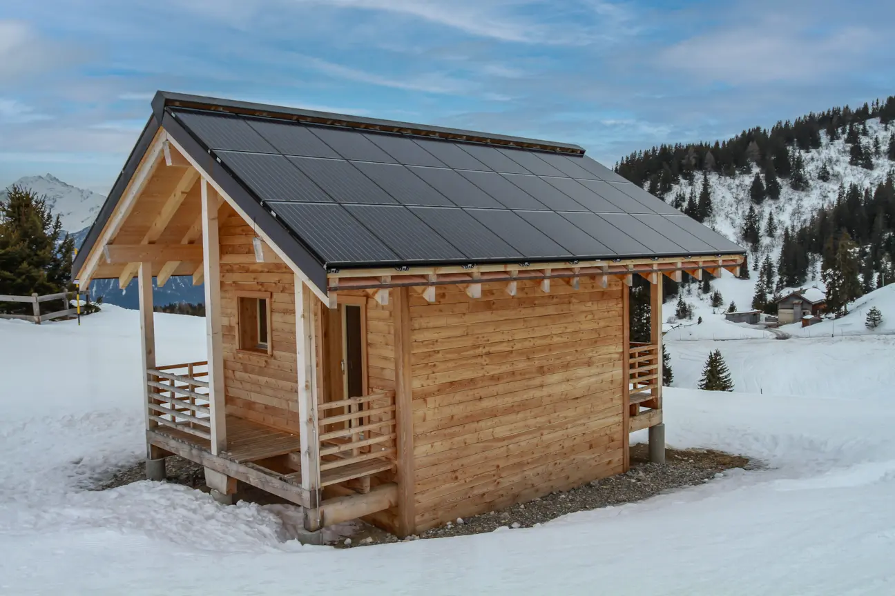 Chalet en rondins avec toit solaire Photon Solaris dans les montagnes enneigées près de Fleurance